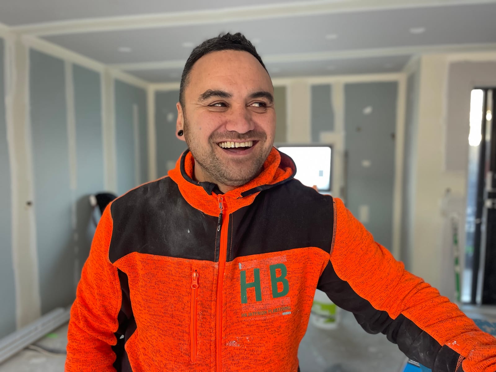 HB Interior Plastering worker in an orange hoodie